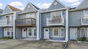A row of townhouses with balconies, white doors, and a clear sky. - Bright getaway w/ daily tickets & beach access (Panama City Beach)