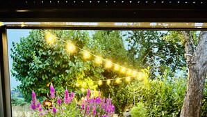 Un espace extérieur accueillant avec une table, une bougie et un verre d’eau.