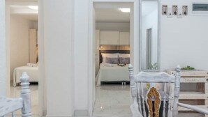 A hotel room with a bed, a bedside table, a mirror, and a wall-mounted light fixture. - Eden Mediterranean House (Vrsine)