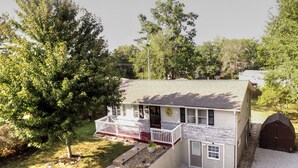 A two-story house with a front porch, a garage, and a small garden area.