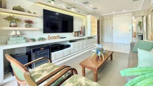 Una sala moderna con televisor de pantalla plana, muebles de madera y objetos decorativos.