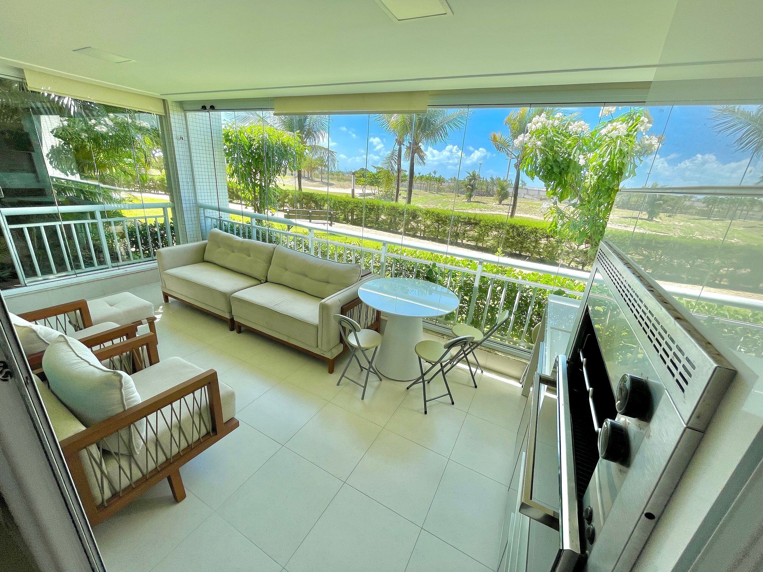 A balcony with a sofa, chairs, and a table.