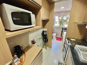 A compact kitchenette with a microwave, coffee maker, and a small sink. - Golf Ville Resort (Aquiraz)