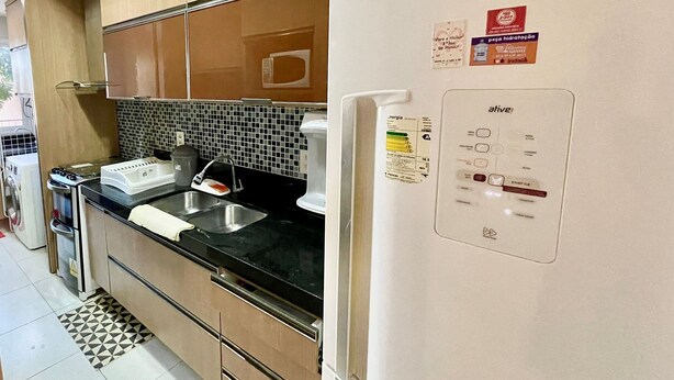 A kitchen with a refrigerator, stove, sink, and microwave. - Golf Ville Resort (Aquiraz)