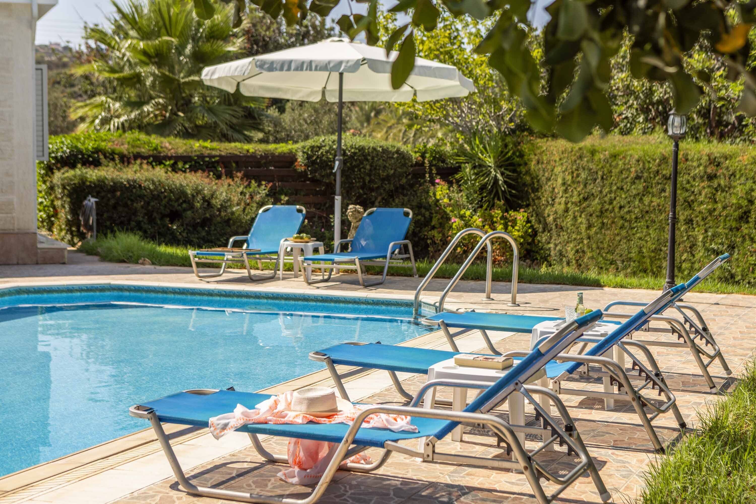 A swimming pool with lounge chairs and umbrellas.