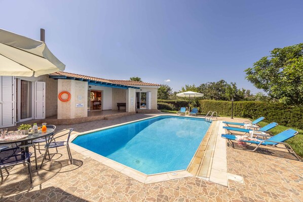 Relax by the pool, surrounded by a stable deck and a covered dining area.