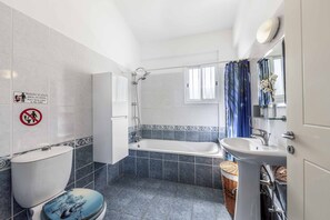 Bathroom features a white toilet, bathtub, and sink with a mirror above.
