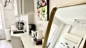A modern kitchen with a marble countertop, a coffee machine, and a kettle. - soho london suite (London)