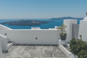 A rooftop terrace with a view of the sea and islands. - Anemos Family Suites (Santorini)