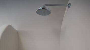 A shower with a handheld showerhead and a wall-mounted faucet.