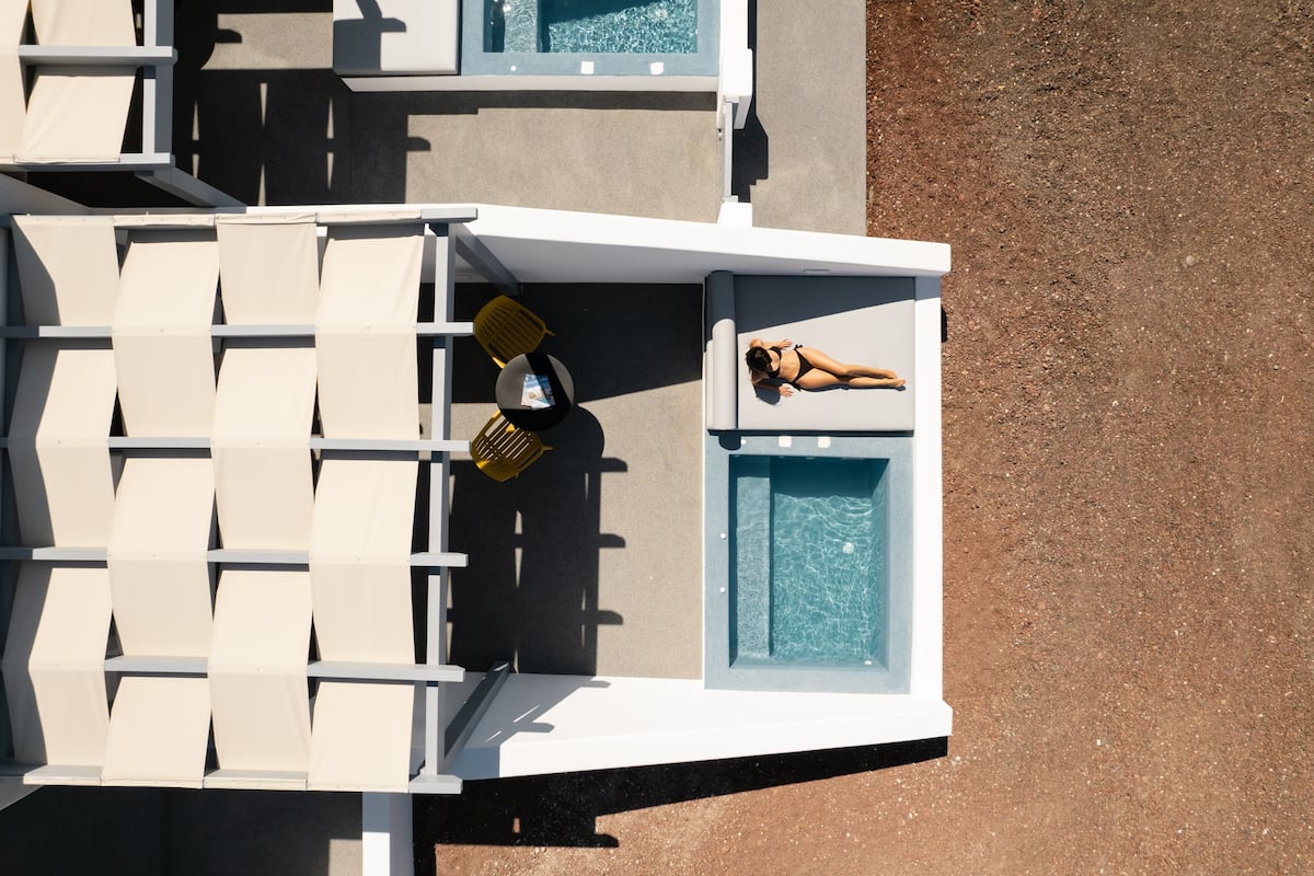A rooftop pool area with lounge chairs and a pool.