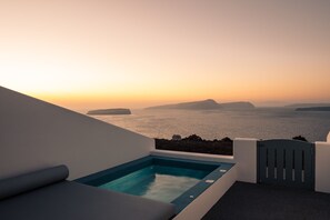 Una piscina infinita en la azotea con vistas al mar y a las islas al atardecer.