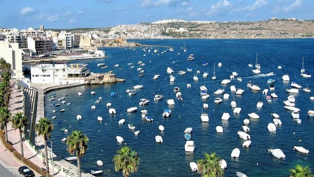 A marina with numerous boats docked, a coastal cityscape in the background, and a clear sky. - Spacious 3 bedroom apartment within walking distance from Bugibba seafront  (St. Paul's Bay)