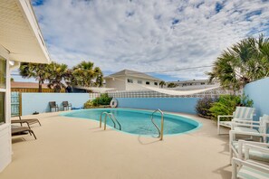 Relax by the pool surrounded by lush greenery and lounge in style.