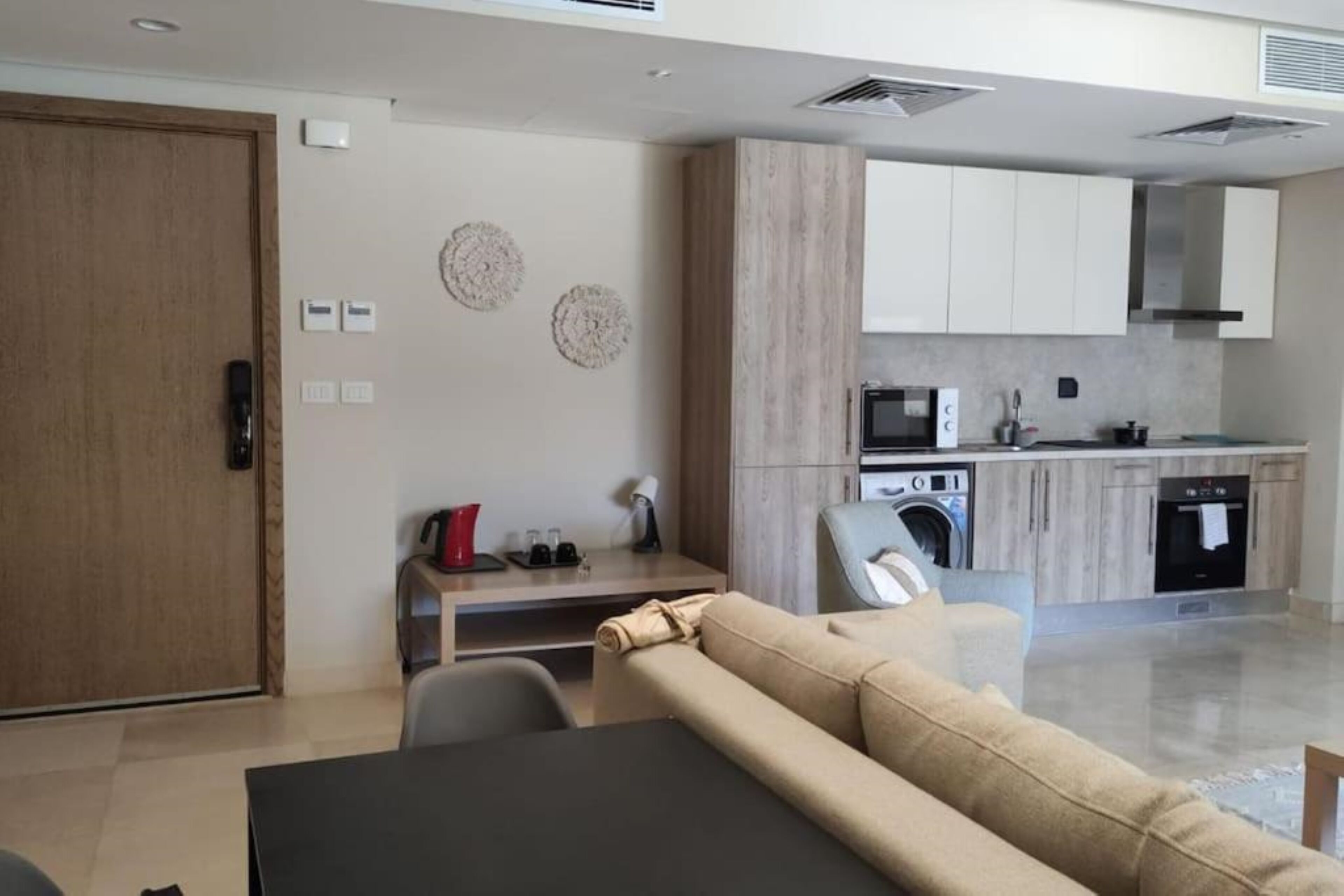 Uma sala de estar moderna com sofá, mesa de jantar e cozinha equipada.