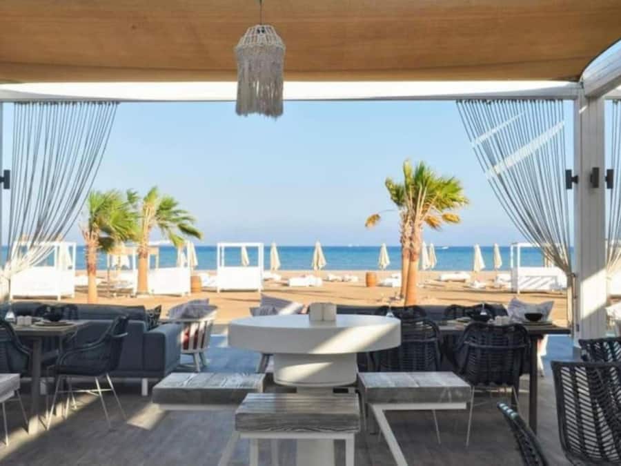 Een overdekt terras met uitzicht op het strand en de zee.