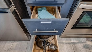 Een keuken met twee lades, waarvan één is gelabeld 'kookgerei' en de andere 'keukenbenodigdheden'.