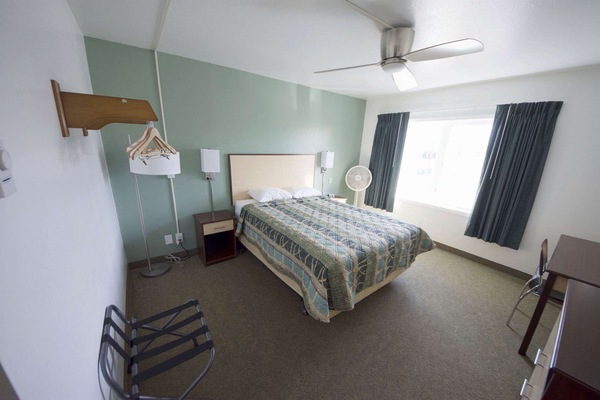 Bedroom interior with bed, lamp and hangers