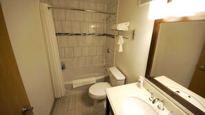 A compact bathroom with a shower, toilet, and sink. - Rewak Studios: Gigabit Powered WiFi! Hotel-Style Furnished Studios--Easy Walk to Lots of Places (Fairbanks)