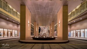 A spacious lobby with a central fountain, high ceilings, and modern lighting fixtures. - The Song Vung Tau Apartment Cookies (Ho Chi Minh City)