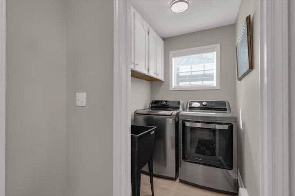 A compact kitchen with a washing machine, dryer, and oven.