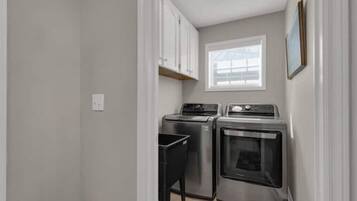 A compact kitchen with a washing machine, dryer, and oven.