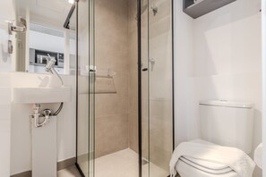A modern bathroom with a glass-enclosed shower, a white sink, and a toilet. - 360 VN On Lorena (São Paulo)