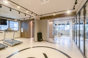 A modern gym with treadmills, a weight bench, and a large mirror. - 360 VN On Lorena (São Paulo)