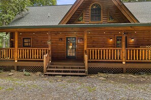 A log cabin with a front porch, a central door, and two windows on the upper level. - Firefly Lodge; 15 minutes to the Polar Express! (Bryson City)