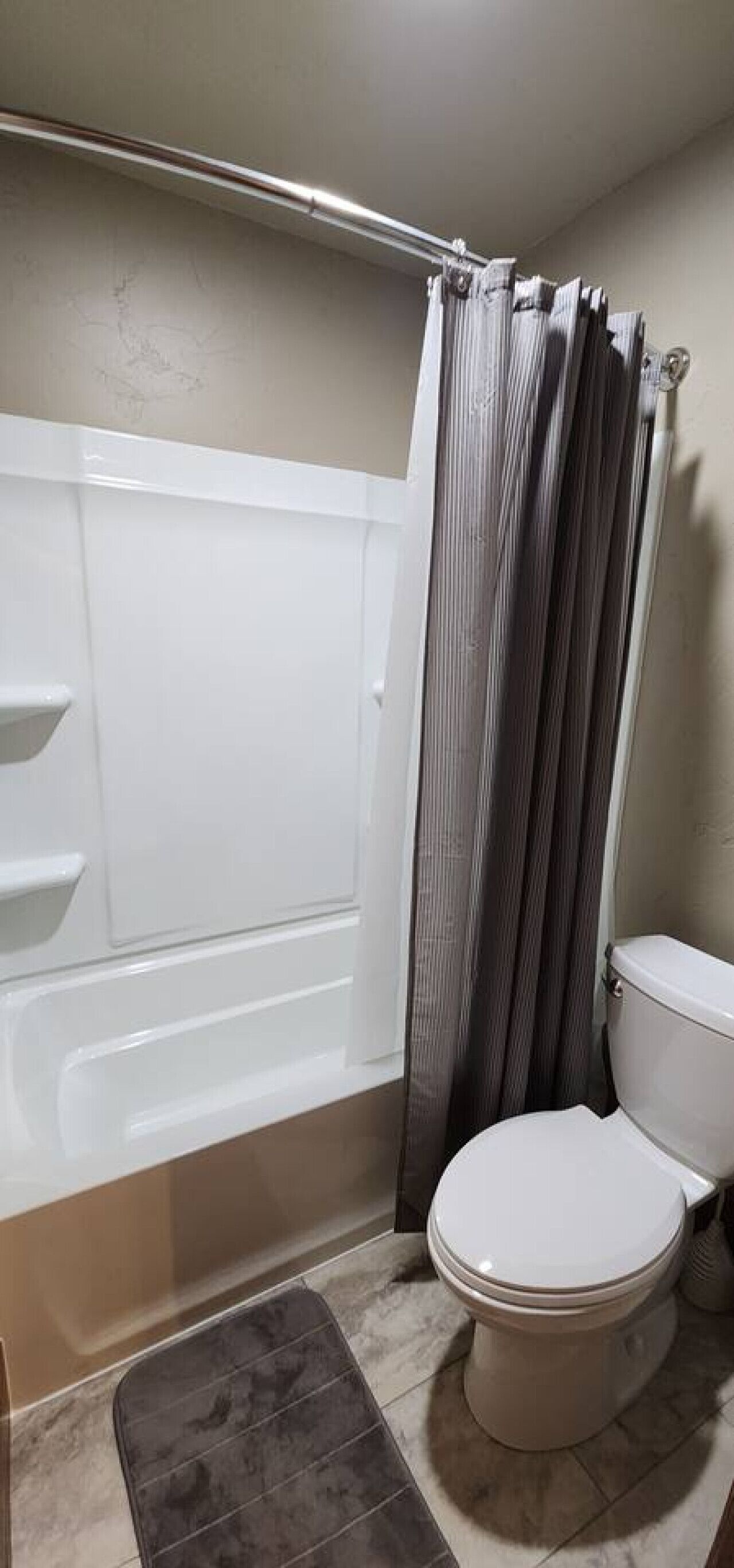 Un baño con bañera, inodoro y cortina de ducha.