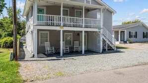 A two-story house with a balcony, a covered porch, and a front staircase. - The Teal Door is a 3 Bedroom 1 Bath Unit. Sleeps 6. Linens Included! (Carolina Beach)