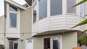 Ein Eckhaus mit Erker, einer Haustür und einer kleinen Terrasse.