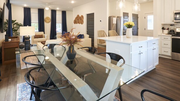 Een moderne keuken met witte kastjes, een centraal eiland en roestvrijstalen apparatuur.