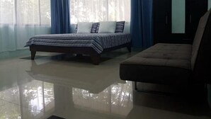 Un dormitorio con cama, sofá y armario.