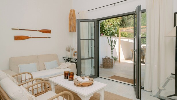 A modern living room with a sofa, a coffee table with a basket, and two wooden paddles on the wall. - Casa Familia - House for 4 (Sa Pobla)
