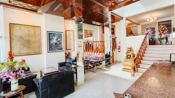 A spacious living area with a high ceiling, wooden beams, a staircase, and a view of a balcony. - Lido Hotel (Santa Cruz)