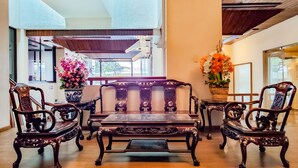 A traditional-style room with a sofa set, a table, and two chairs. - Lido Hotel (Santa Cruz)