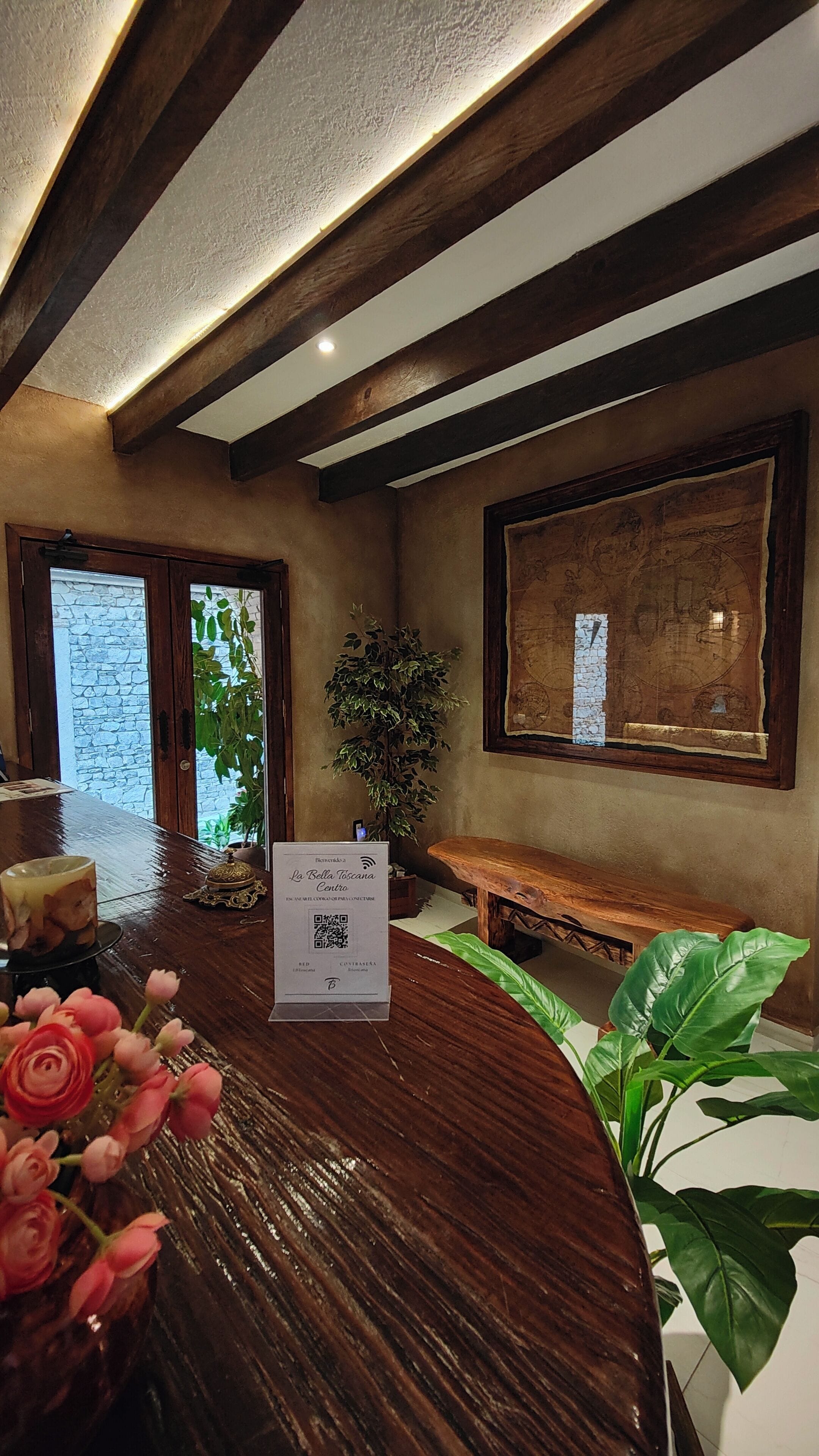 A reception area with a wooden reception desk, a map on the wall, and a potted plant.