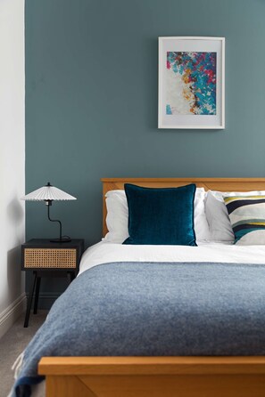 Cozy retreat with a single bed, nightstand, and abstract art.