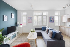 Relax in this stylish living room with a grey sofa, flat-screen TV, and white coffee table.