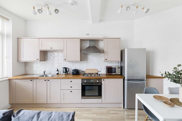 Enjoy cooking in this well-equipped kitchen with a gas stove, oven, microwave, and refrigerator.