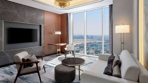 A modern living room with a large TV, comfortable seating, a small table, and a view of the city. - Embassy Suites By Hilton Dubai Business Bay (Dubai)