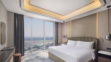 Une chambre d’hôtel moderne avec un grand lit, un bureau, une chaise et une vue sur la ville.