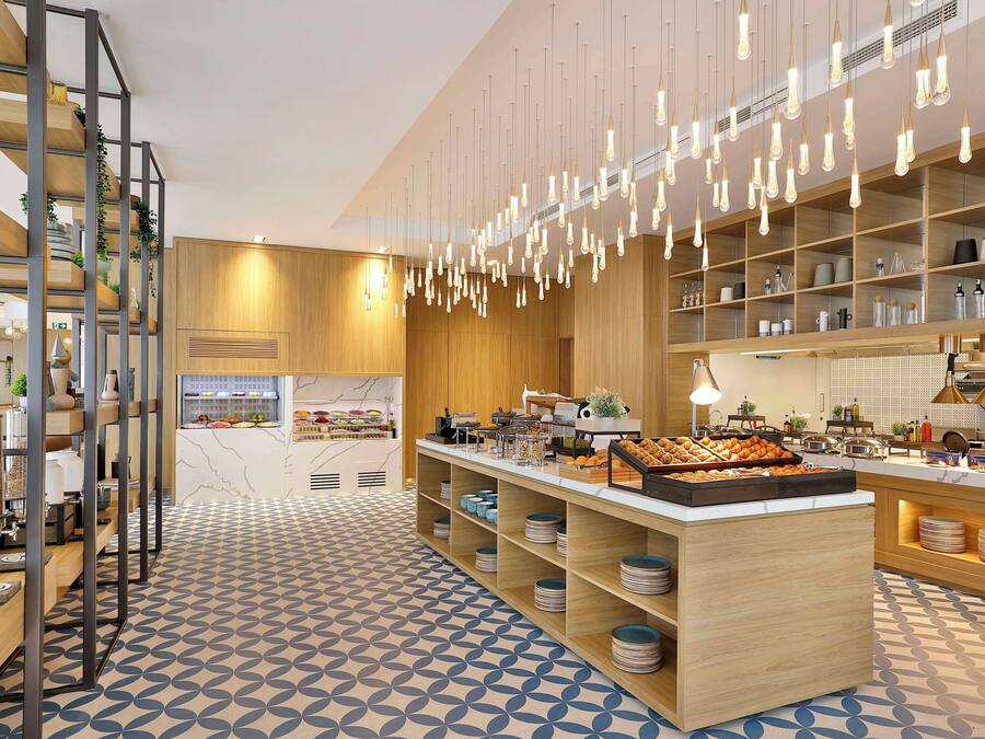 Een moderne keuken met houten planken, hangende lampen en een centraal eiland met etalages vol eten.
