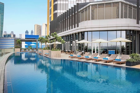 Piscine extérieure, parasols de plage, chaises longues. Hilton Garden Inn Dubai Business Bay