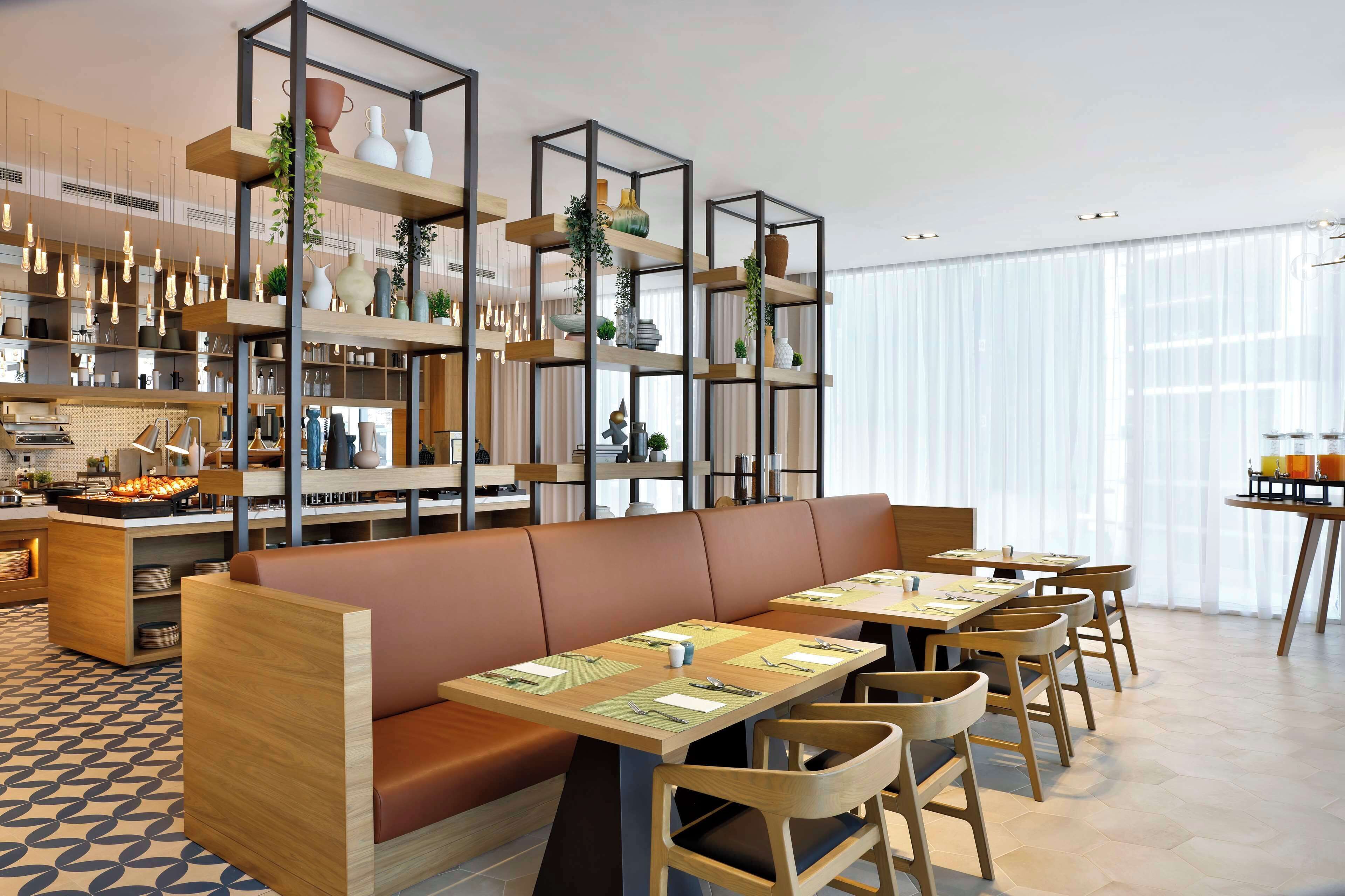Un restaurante moderno con muebles de madera, un espacio central para sentarse y estantes con plantas y objetos decorativos.