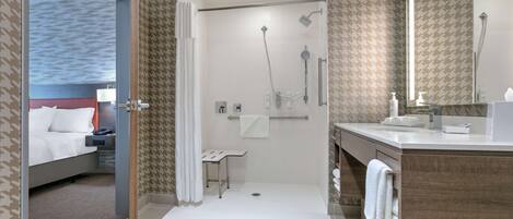 A modern bathroom with a shower, toilet, and sink.