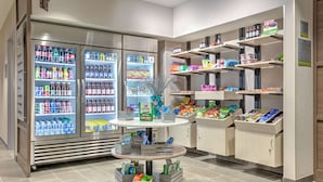 A well-organized grocery section with refrigerated beverages, fresh produce, and packaged goods on shelves. - Home2 Suites By Hilton Tulsa Airport (Tulsa)