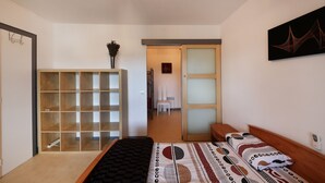 A bedroom with a bed, a wardrobe, a desk, and a chair.
