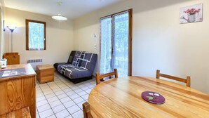 Un salón acogedor con un sofá, una mesa de comedor y un aparador de madera.